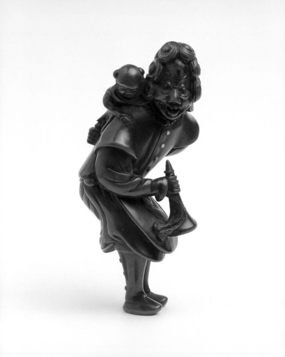 Netsuke, wood carved with Dutchwoman with a trumpet and a child, Japan, 18th century.