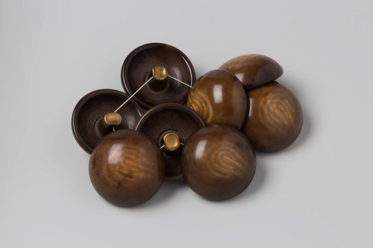 Button (8 items), domed, of brown and beige plastic (celluloid?) with copper eye