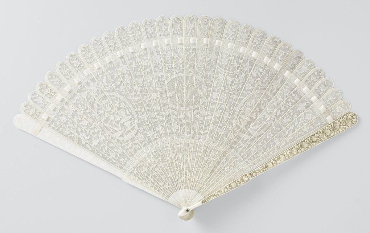 Brisé fan of ivory, carved in relief with flowers and scrolls, and fitted with three oval medallions, the central one bearing 'Sacred to Love'