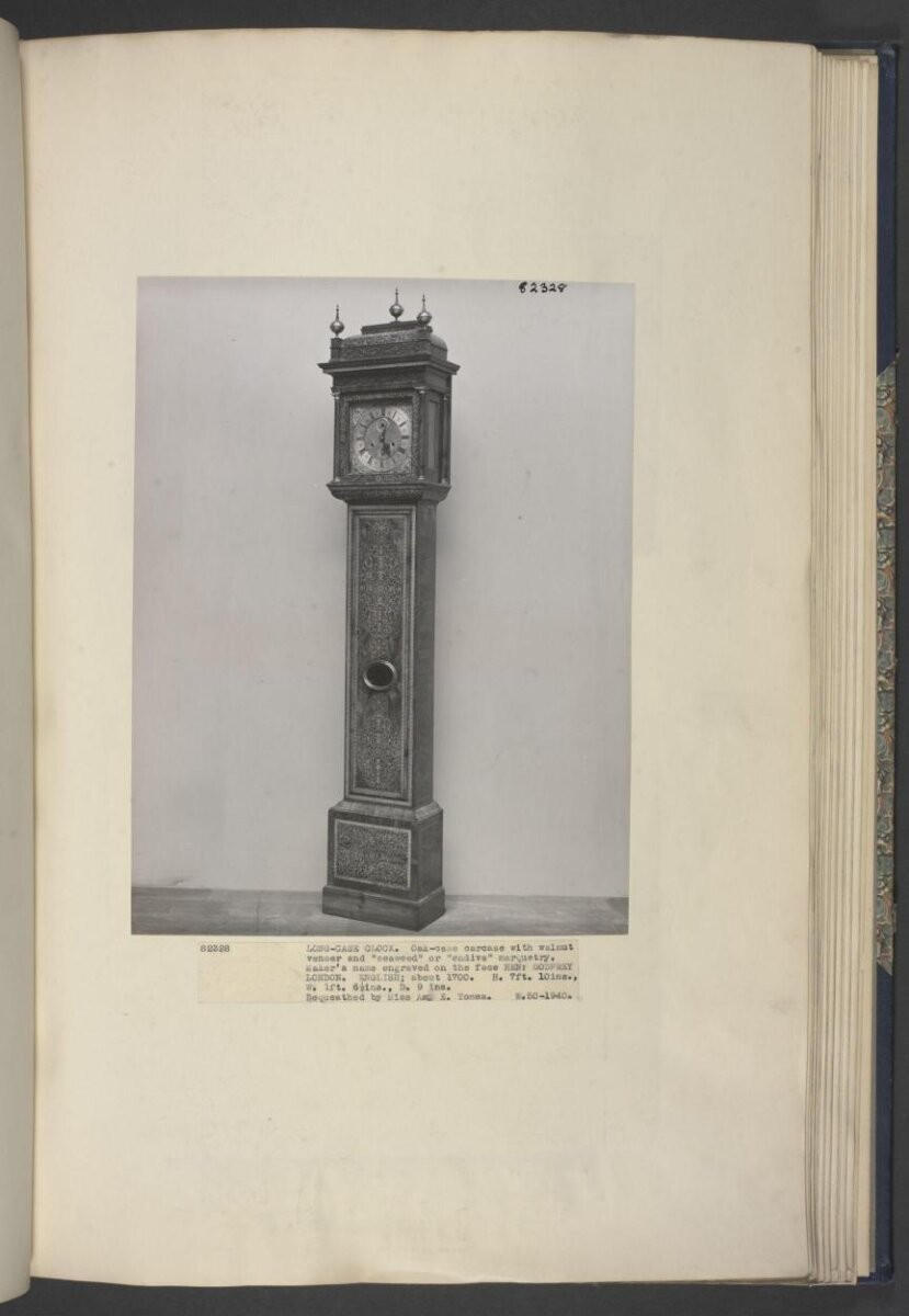 A long-case clock with 8-day movement, the case veneered in walnut with arabesque marquetry panels, the brass dial with silvered chapter ring, inscribed 'HENR- GODFREY LONDON'.