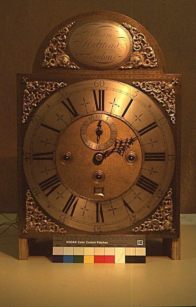 An eight-day longcase clock in an oak case veneered in walnut, with scrolling marquetry designs in rosewood, sycamore, pear and walnut, the brass dial signed by William Halstead, London.