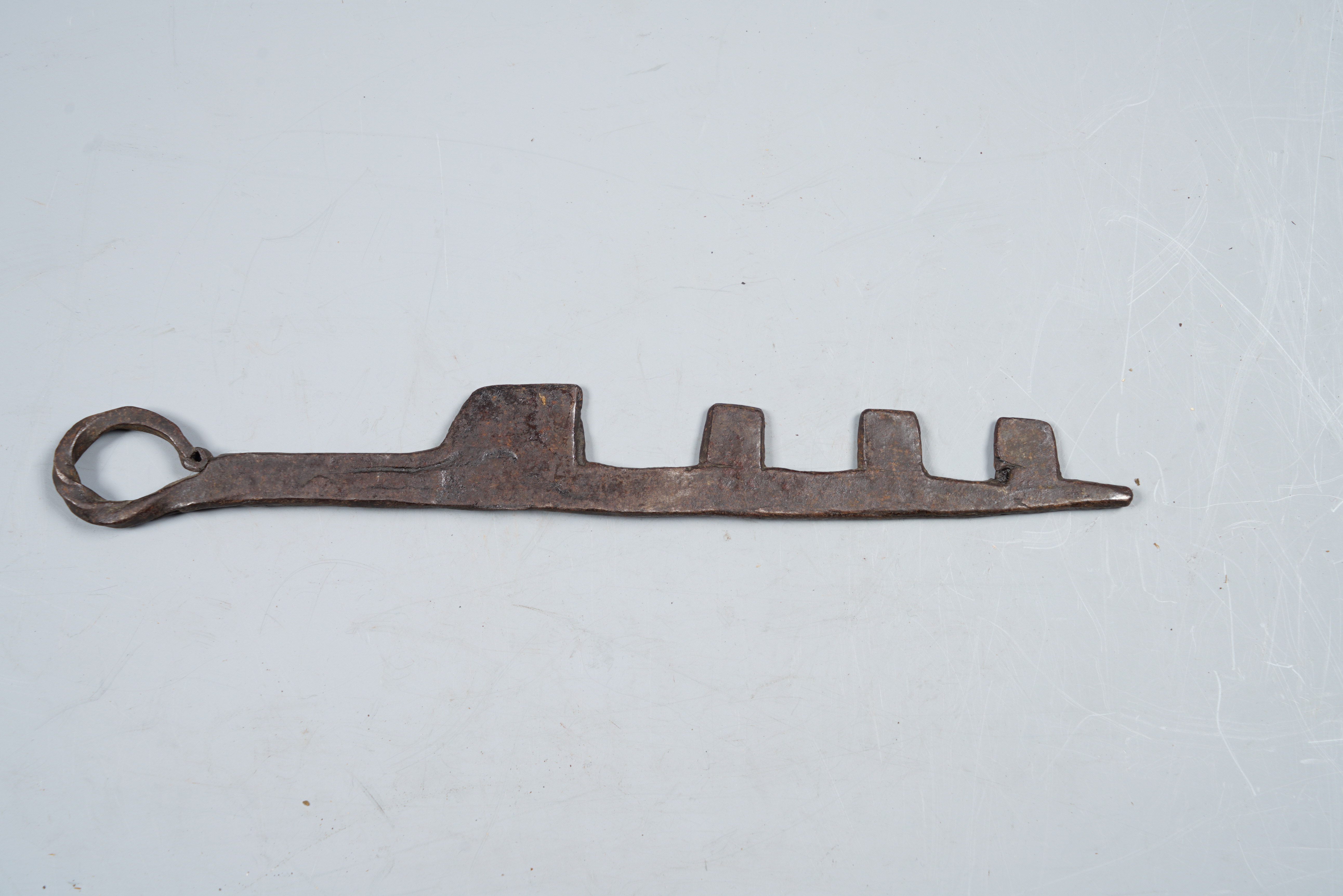 Hot-worked iron key, with 4 teeth, with round handle.