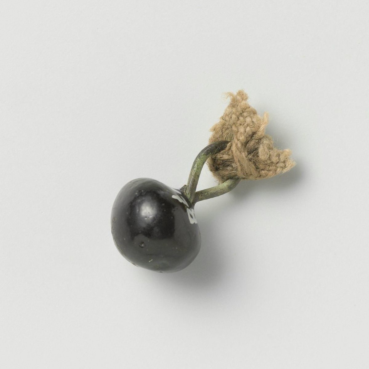 Button consisting of a round sphere with a copper wire eye