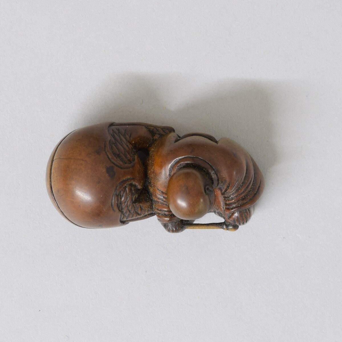 Netsuke, figure of a sleeping Buddhist monk with a mokugyo bell, Japan, 19th century
