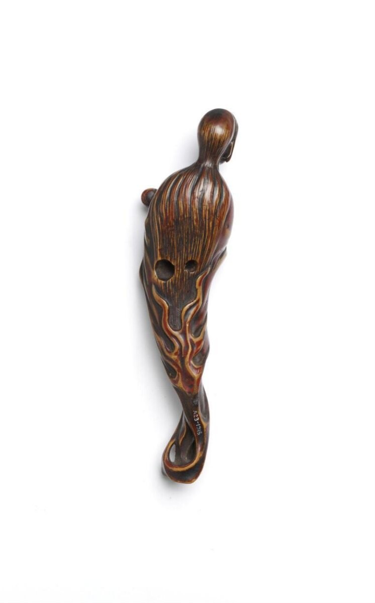 Netsuke, wood carved and lacquered with the ghost of Oiwa carrying a figure of Jizo, Japan, Late 19th century.