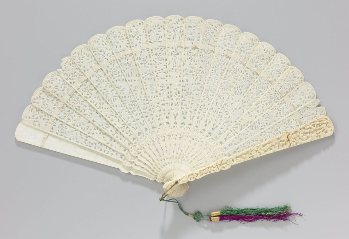 Brisé fan of bone (?) with pierced and relief-carved sticks, on both sides of which are Chinese figures, houses and plant and floral motifs