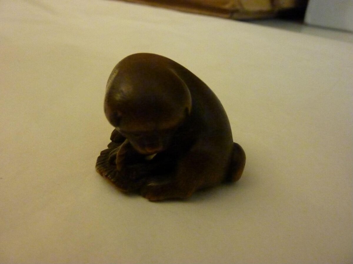 Netsuke of a puppy and a sandal in carved and stained wood, signed Masanao, Japan, 1850-1900