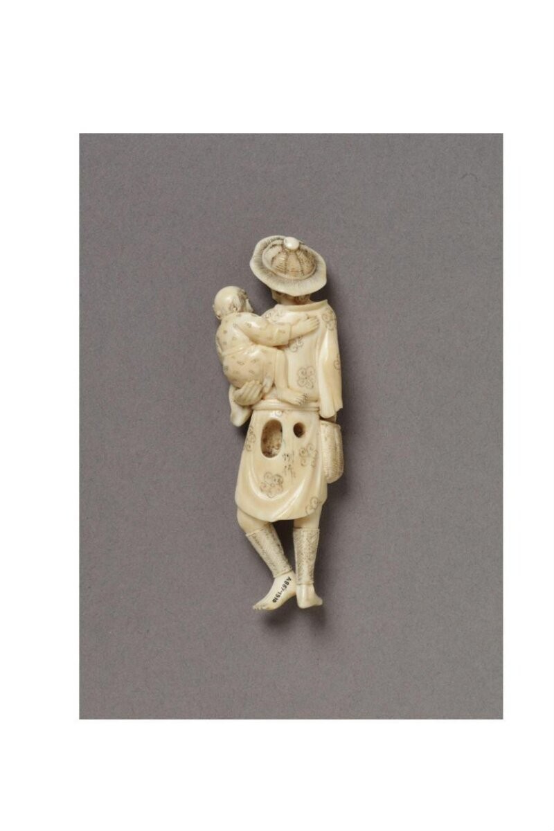 Netsuke of a foreigner and child, carved ivory; signed Senshu, Japan, 19th century.