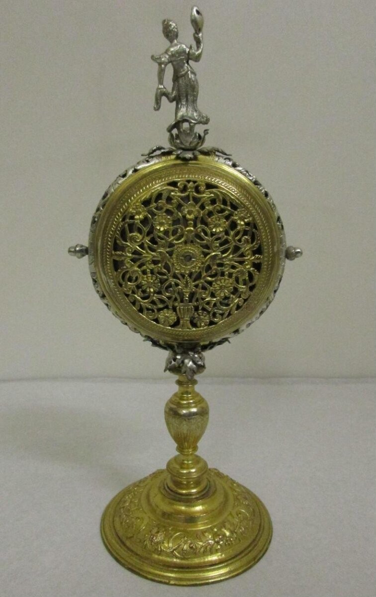A striking alarm clock in a square gilt-brass case surmounted by a silver figure representing Prudence