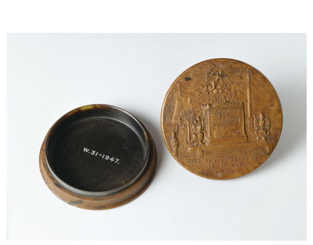 Circular snuff box, of burr maple or birch, steamed and stamped with a commemoration of the bravery of the Imperial Guard at Waterloo. French, ca. 1815