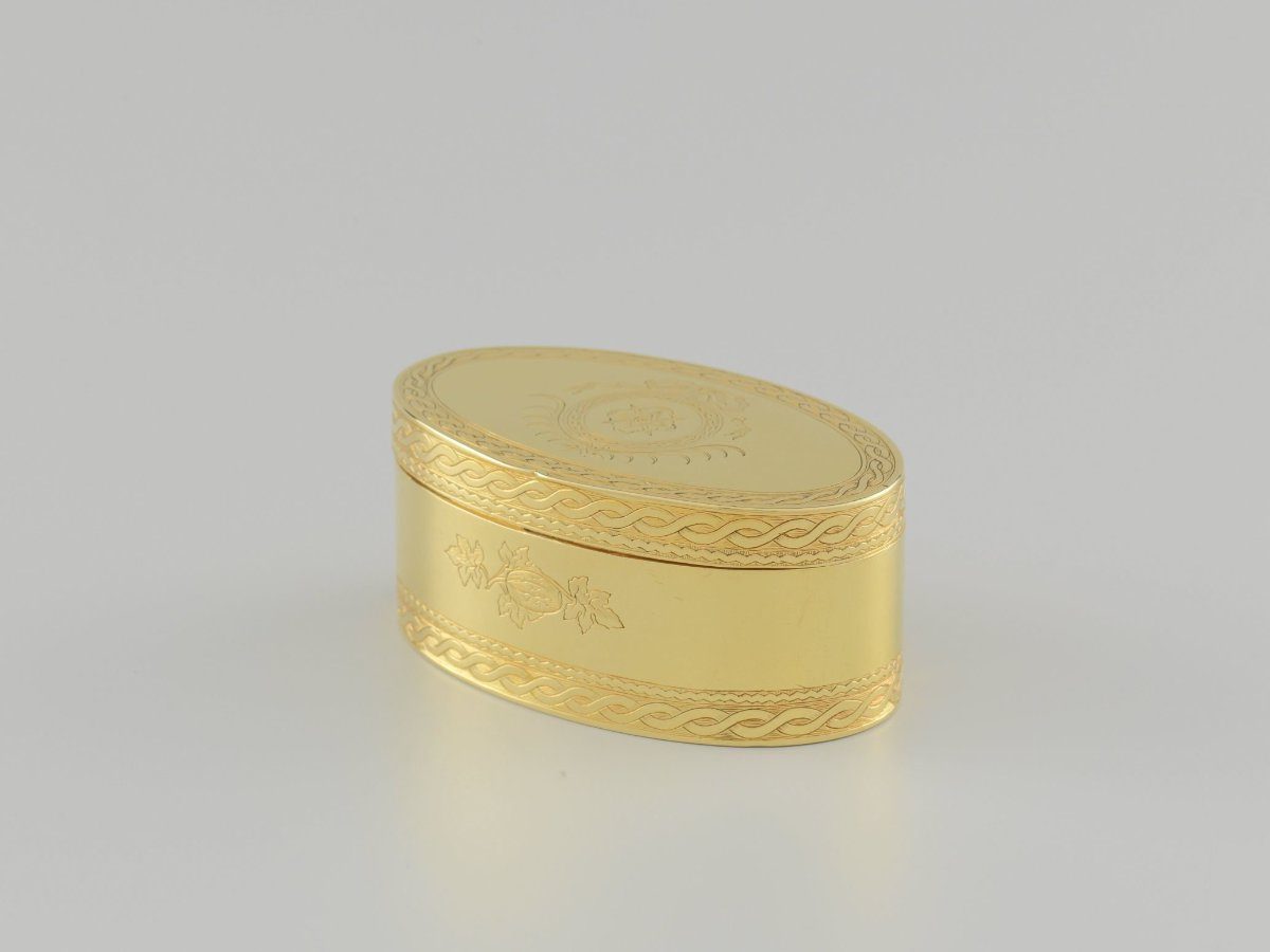 Gold snuffbox, oval with straight sides. On front and back an engraved pumpkin branch with fruit and four leaves