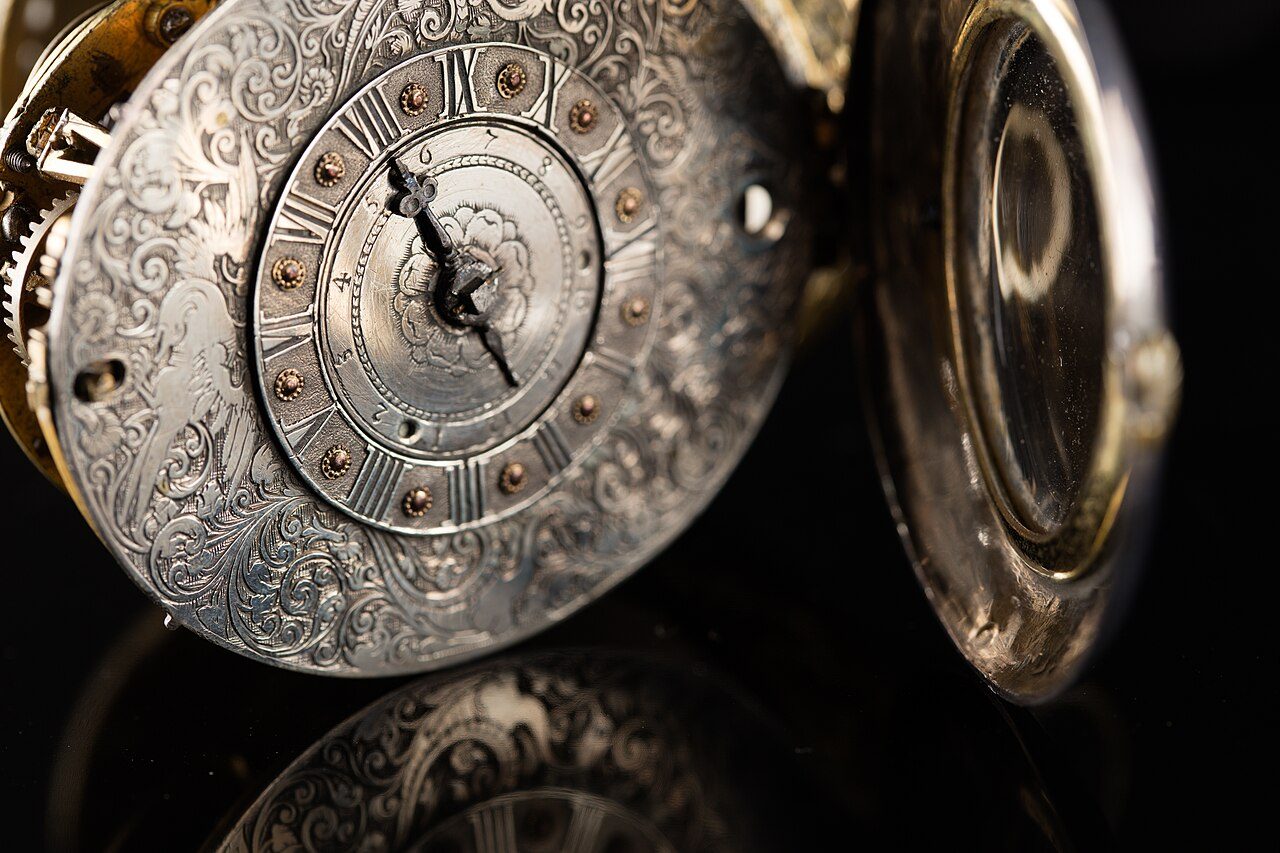 Oval alarm pocket watch with pierced brass sides and silver covers