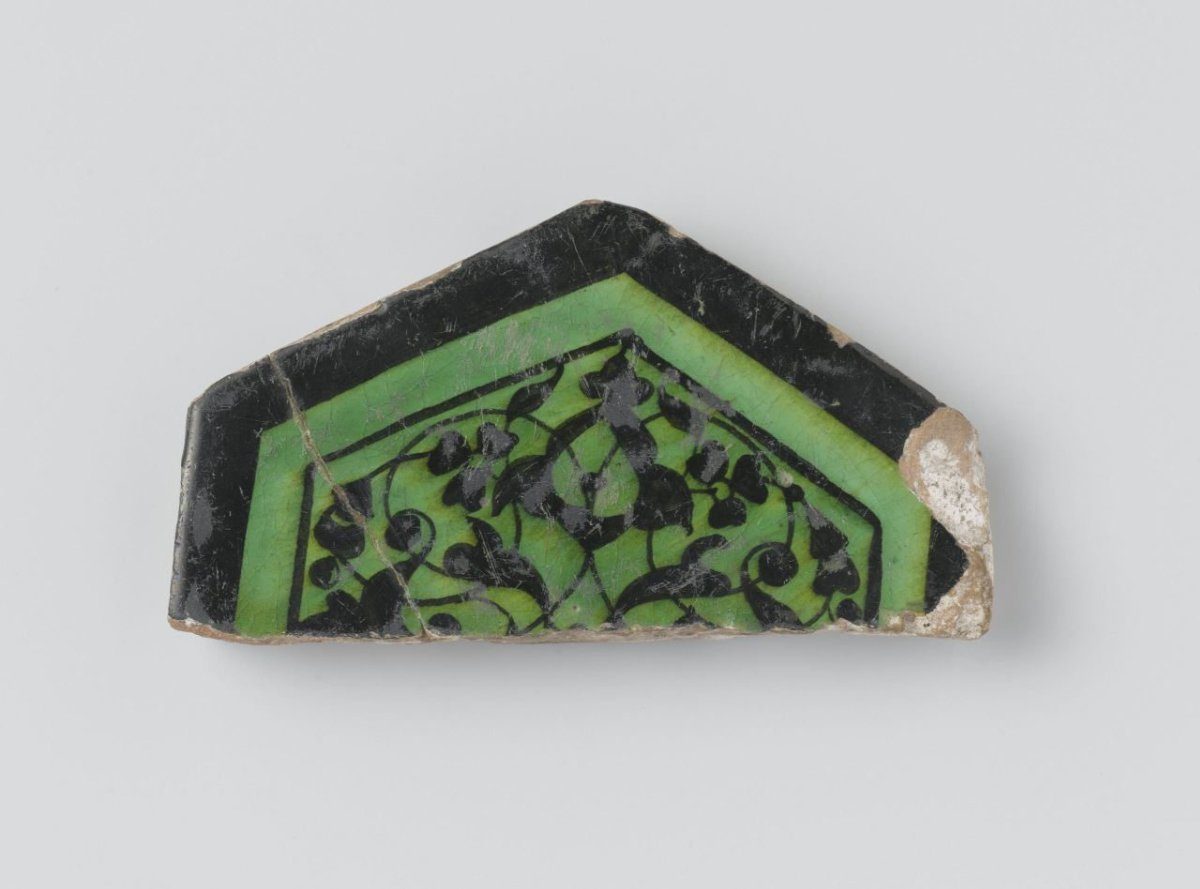 Half of a hexagonal tile with floral scrolls