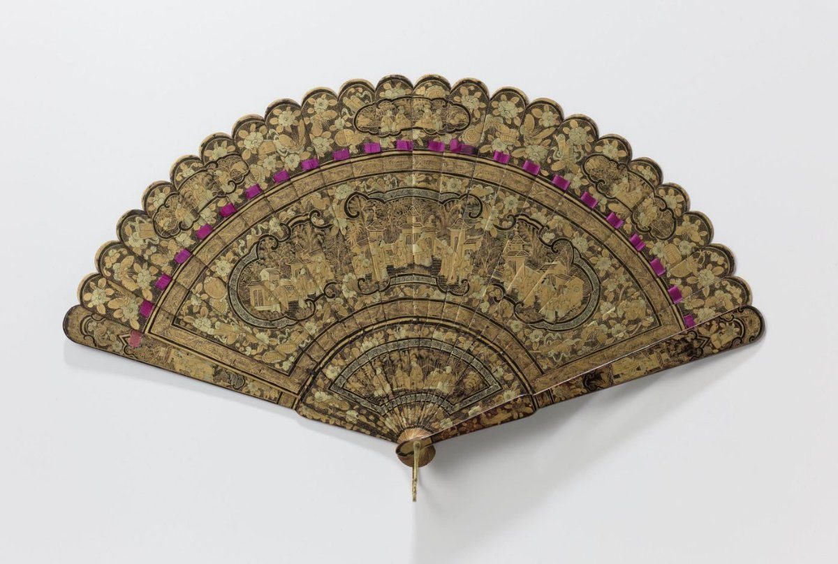 Brisé fan of wood with a Chinese scene on both sides in a cartouche in lacquerwork of two colours of gold on a black ground