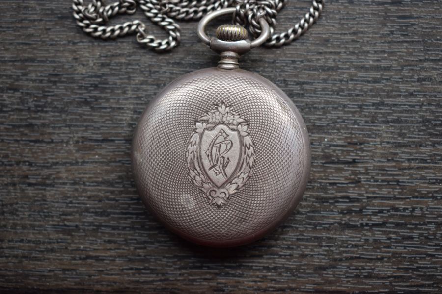 The silver-made Omega pocket watch presented by General Henri Berthelot to Father Constantin I. Roșescu, a Romanian Orthodox priest and teacher from Iași, that became his friend during the WWI French campaign in Romania. The backplate is engraved with "CR", Roșescu's initials. Fa